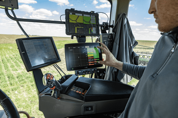 Grower interacting with a display conveniently mounted in the cab 